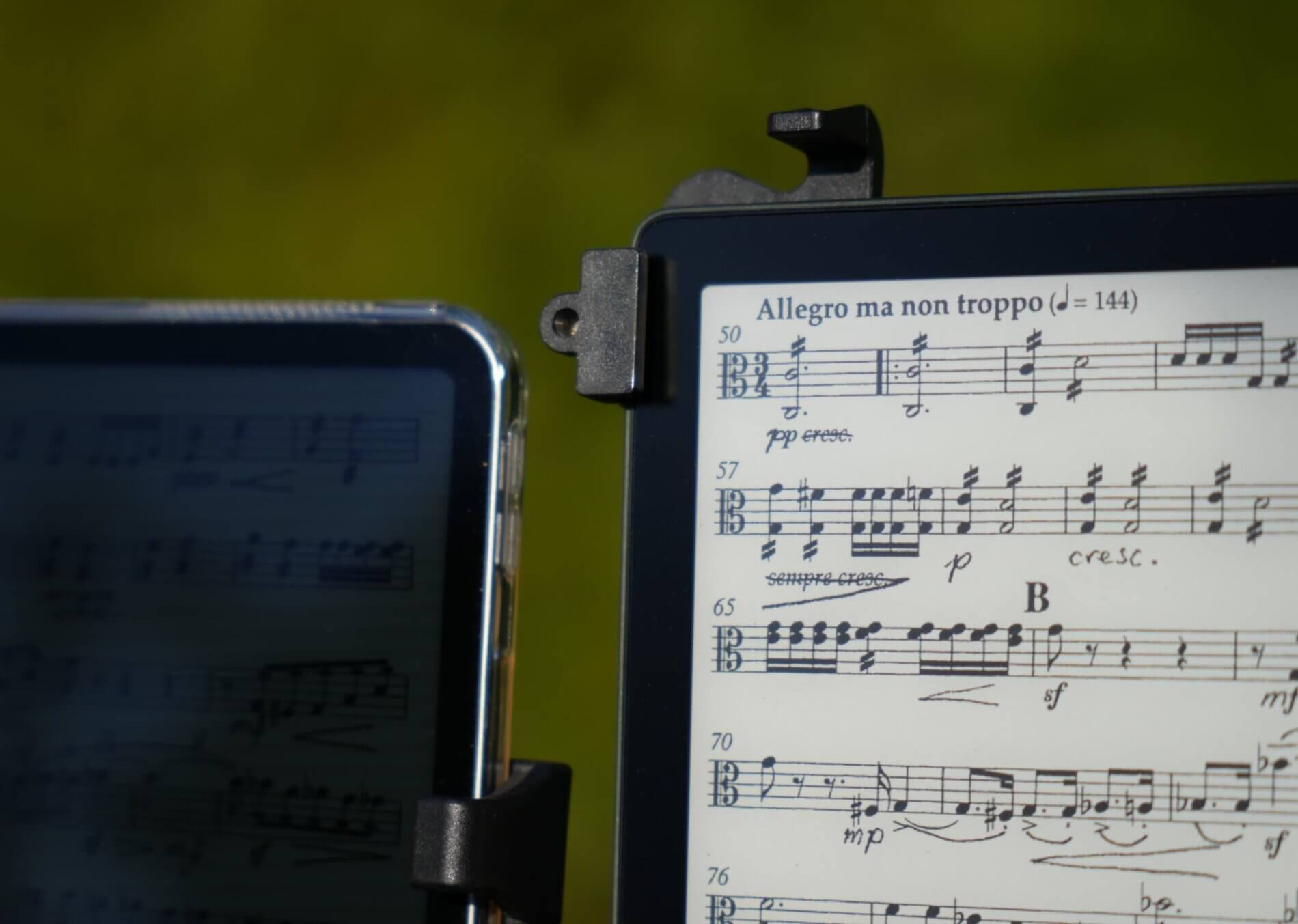 Une liseuse et une tablette (iPad) affichant des partitions de musique en plein soleil